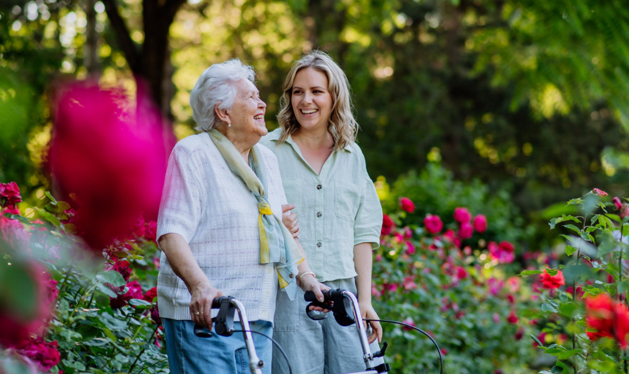 caregiver and senior walking in park