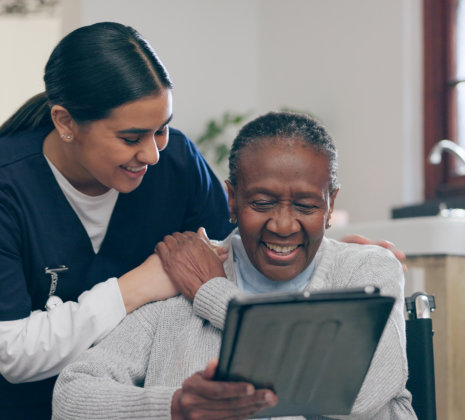 senior and caregiver watching on tablet