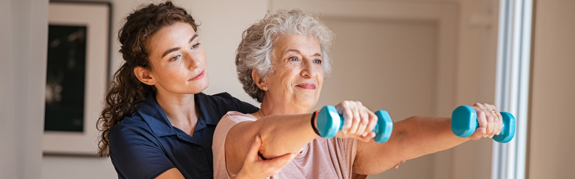 caregiver assisting senior on her exercise