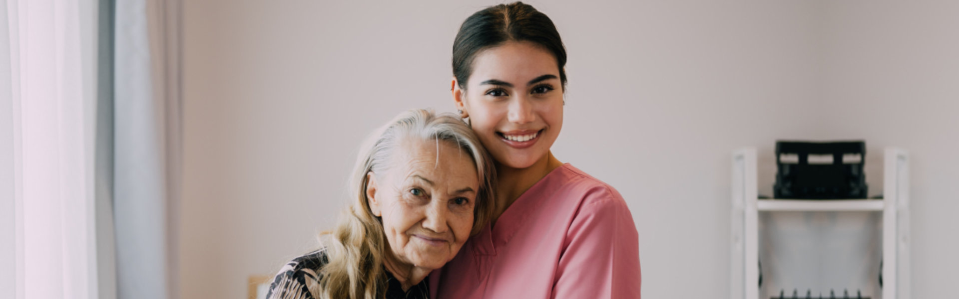 caregiver and senior hugging